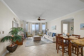 A spacious living area with a balcony, a dining table, and a ceiling fan. - Gulf-Front Luxury Condo on Pensacola Bch 2Bd/2Ba, Pool, Balcony (Pensacola Beach)