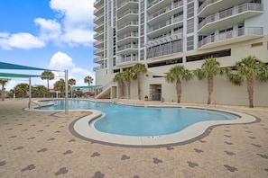 A swimming pool with a wavy edge, surrounded by a tiled deck. - Gulf-Front Luxury Condo on Pensacola Bch 2Bd/2Ba, Pool, Balcony (Pensacola Beach)