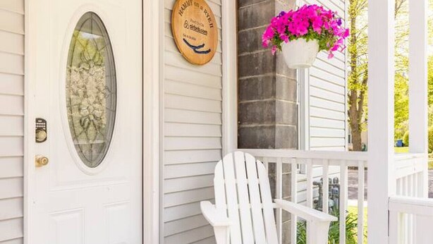 A white door with a glass panel, a wooden plaque, and a white Adirondack chair on a porch with a white railing. - Hammy on a Rye 2 Hammondsport NY (Hammondsport)