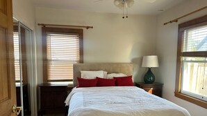 A bedroom with a bed, a nightstand, a lamp, and a ceiling fan. - Spacious Long Beach home, steps to beach & train (Long Beach)