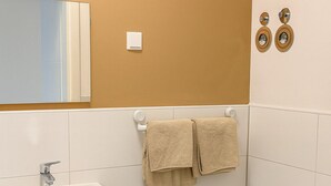 A bathroom with a sink, toilet, and towel rack. - City apartment no. 6 with comfort (Pforzheim)
