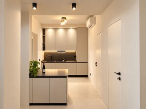 A modern kitchen with built-in cabinets, a central island, and under-cabinet lighting.