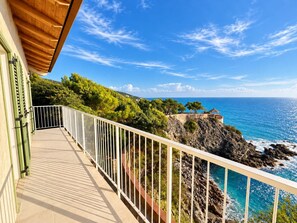 A balcony with a view of the sea and rocky coastline. - Roc Villa - 2 Private Beach Accesses  (Rosignano Marittimo)