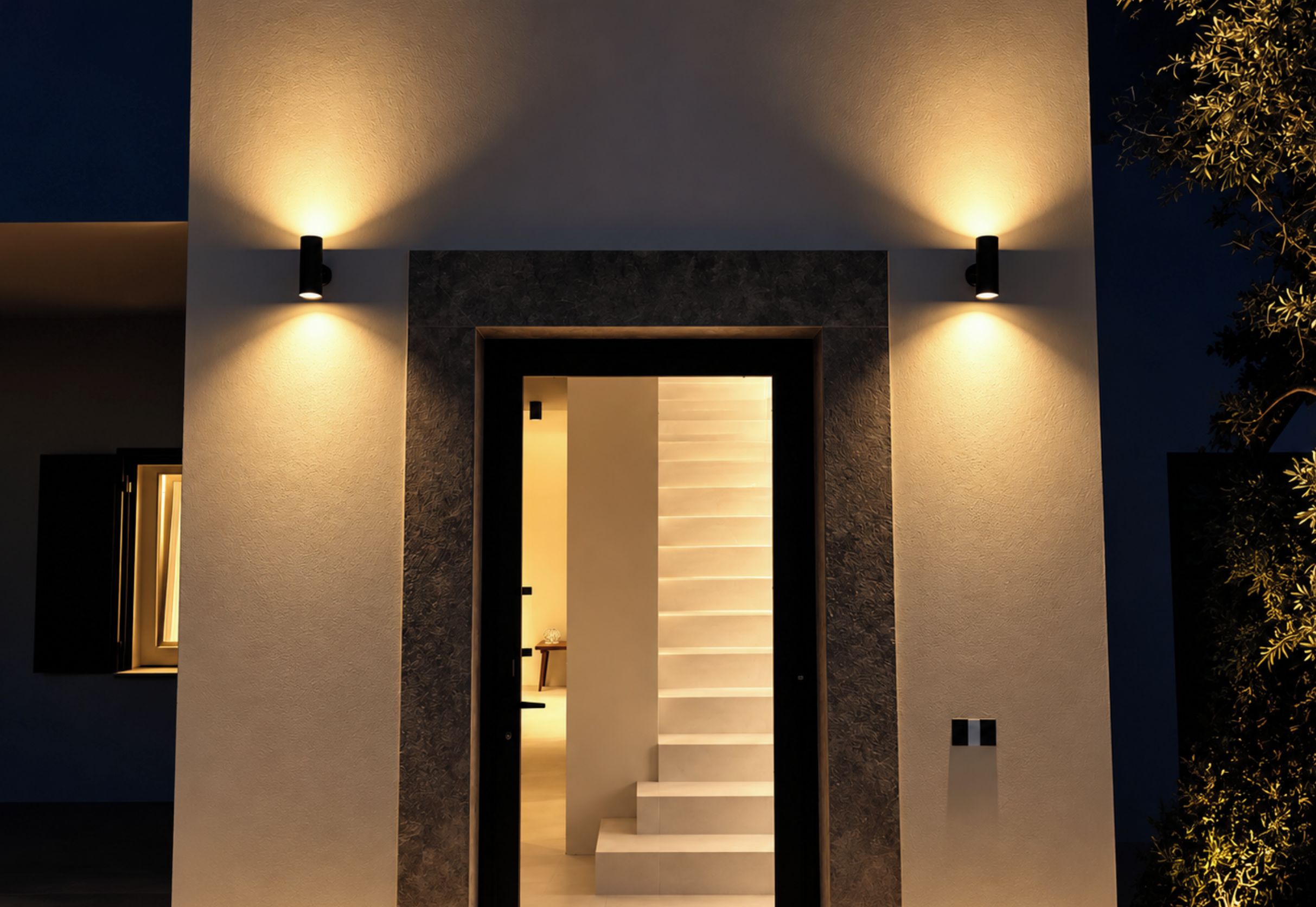 A modern staircase with a minimalist design, flanked by two wall-mounted lights.
