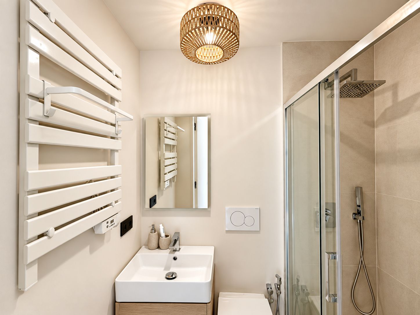Ein modernes Badezimmer mit Duschkabine aus Glas, einem weißen Waschbecken und einem Handtuchhalter an der Wand.