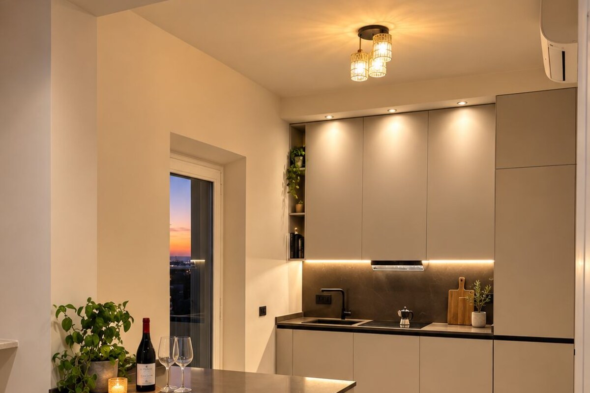 A modern kitchen with a central island, recessed lighting, and a view of the cityscape.