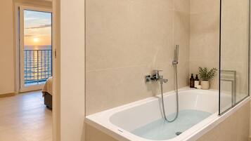 Ein modernes Badezimmer mit einer Badewanne, einer Dusche und einer gläsernen Duschkabine.