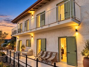 A two-story building with a balcony, outdoor seating, and a well-lit entrance. - Roc Villa - 2 Private Beach Accesses (Rosignano Marittimo)