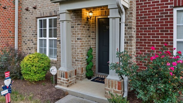A brick house with a black door, a welcome sign, and a mailbox. - Entire home in prime Raleigh with workspace, comm pool, dog park and golf course (Raleigh)