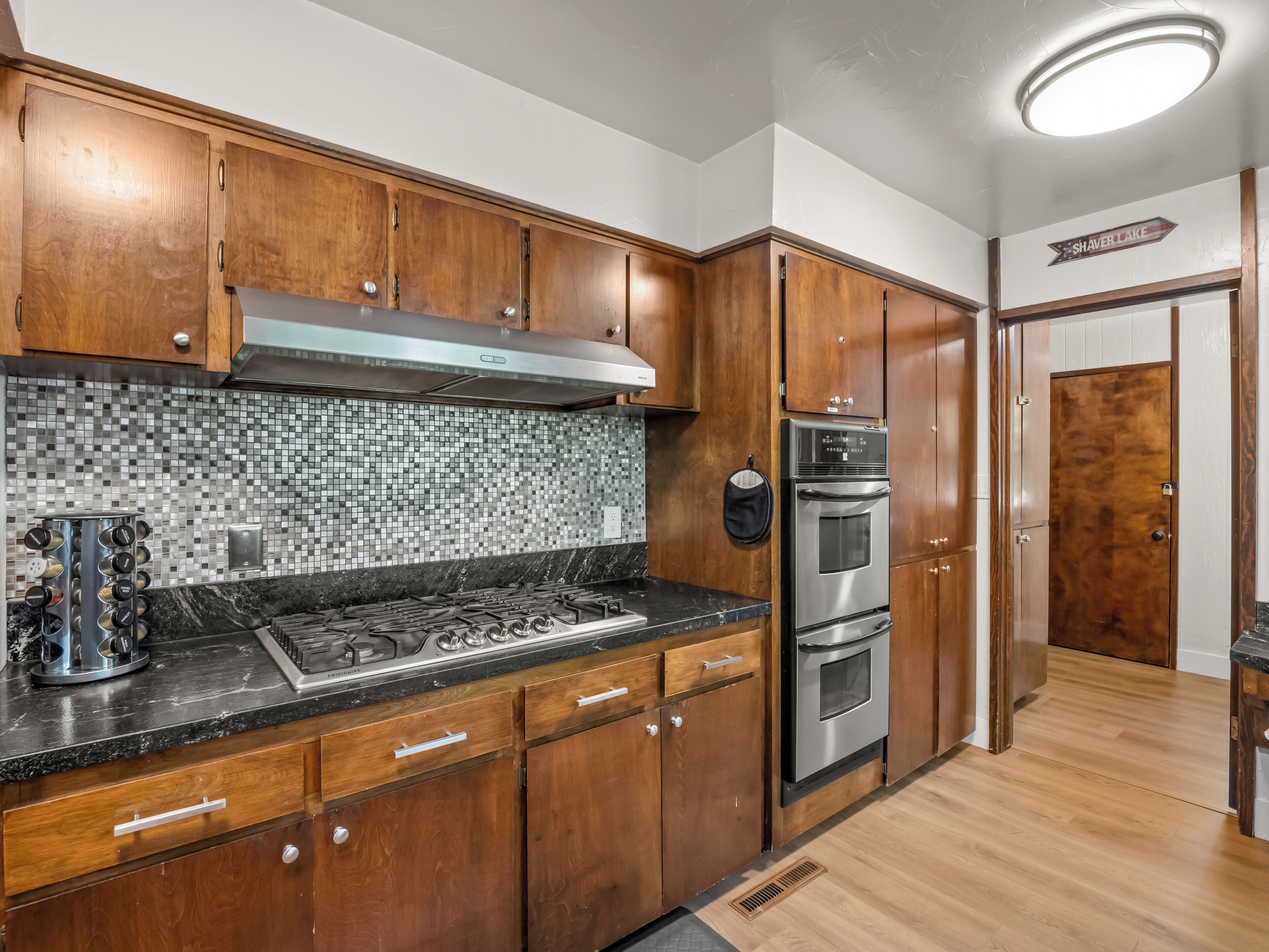 A kitchen with wooden cabinets, a stainless steel range, and a tiled backsplash.