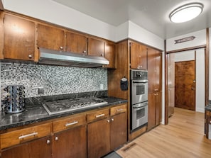 A kitchen with wooden cabinets, a stainless steel range, and a tiled backsplash.