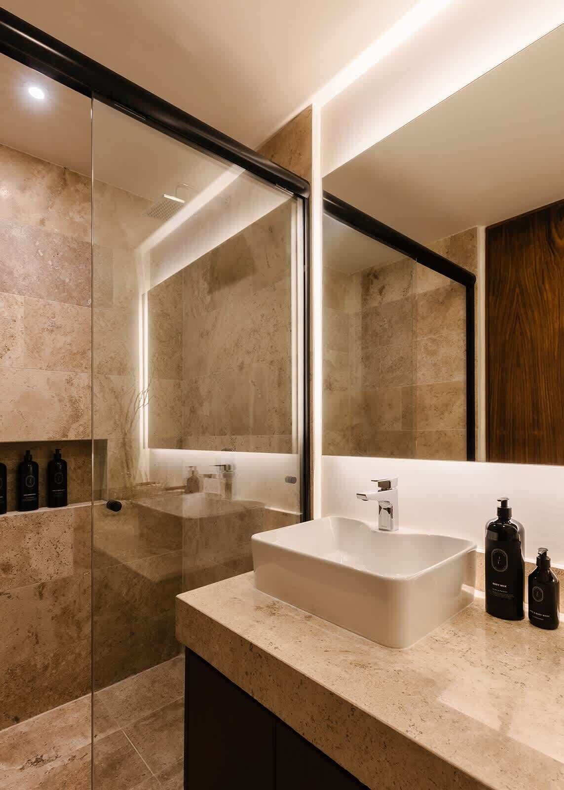 A modern bathroom with a large mirror, a freestanding bathtub, and a marble countertop.