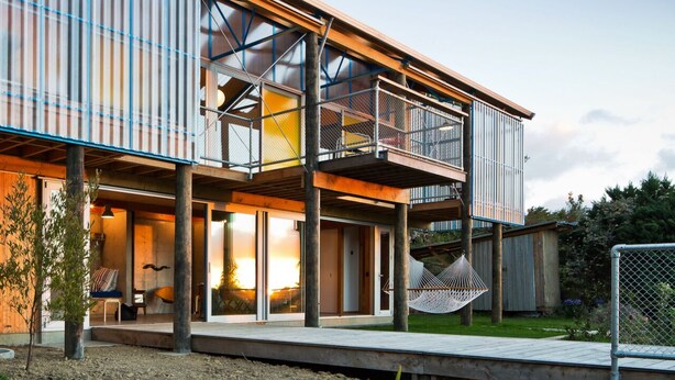 A modern two-story house with a balcony, large windows, and a hammock. - 'The Dogbox' Architectural home in Central Whanganui. (Whanganui)