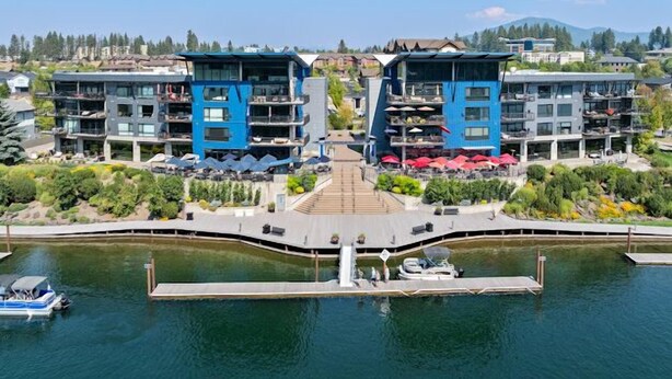 A modern hotel with a central courtyard, two-story buildings, and a dock with boats. - The Loft in Bellerive (Coeur d'Alene)