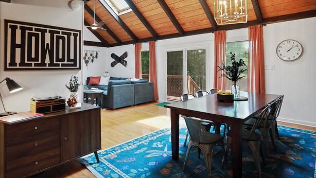 A spacious living area with a high ceiling, a dining table, and a cozy seating arrangement. - Modern Chalet with Hot Tub, Fire Pit & Mountain Views in Basye, VA (Basye)