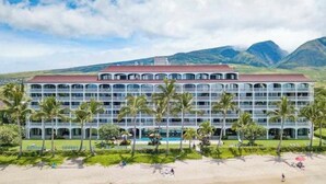 Ein großes, mehrstöckiges Hotel mit einer symmetrischen Fassade, mehreren Balkonen und einem Poolbereich.