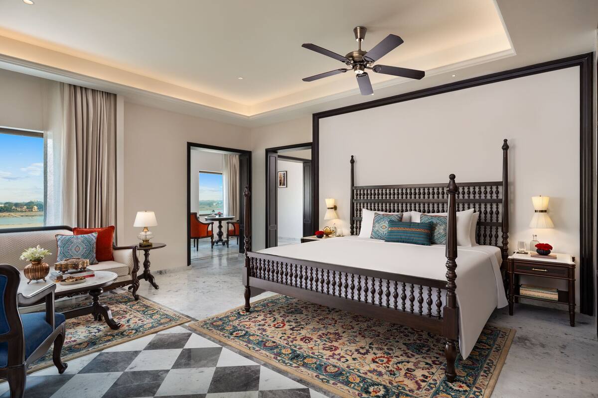 A spacious bedroom with a large bed, a ceiling fan, and a view of the outdoors.