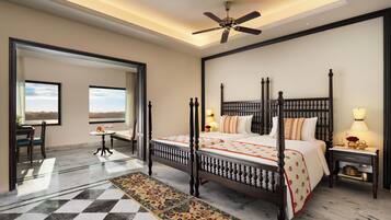 A four-poster bed with a canopy, a ceiling fan, a marble floor with a patterned rug, and a view through an open door.