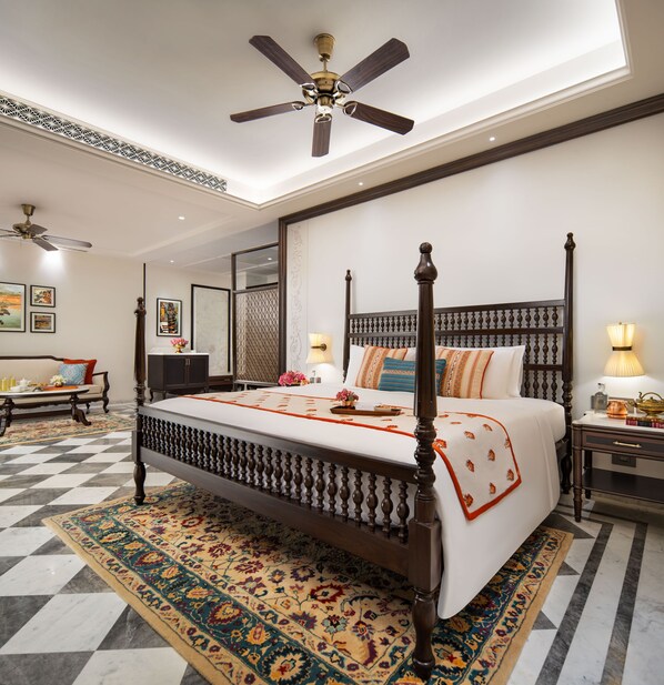A four-poster bed with a dark wooden frame, a checkered floor, and a ceiling fan. - Avantika By The Ganges, IHCL Seleqtions (Varanasi)