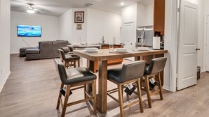 Une cuisine moderne avec un îlot central, des chaises en bois et une table à manger.