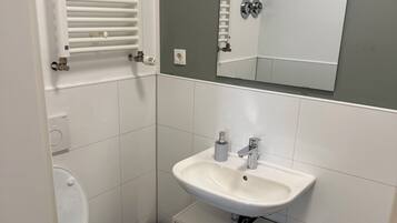 Secador de cabelo, toalhas de banho, sabonete, papel higiênico