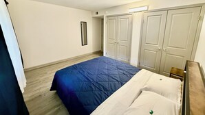 Een slaapkamer met een bed, een kledingkast en een spiegel.