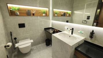 Un baño moderno con un inodoro blanco, un lavabo con encimera de mármol y dos estantes empotrados con plantas y artículos de aseo.