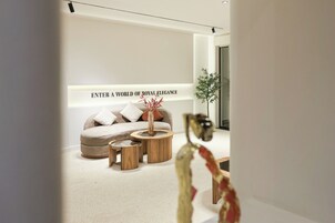 A modern living room with a sofa, two wooden side tables, and a decorative vase.