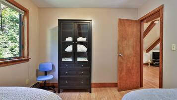 Makuuhuone, jossa on sänky, vaatekaappi, työpöytä ja tuoli.