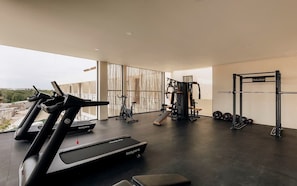 A gym with treadmills, weight machines, and a squat rack.