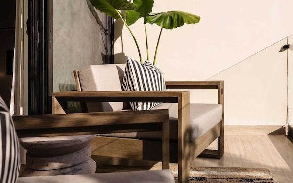A modern living room with a sofa, a wooden coffee table, and a potted plant.