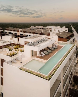Un hĂŽtel moderne dotĂ© dâune piscine sur le toit, dâun espace extĂ©rieur amĂ©nagĂ© et offrant une vue sur le paysage.