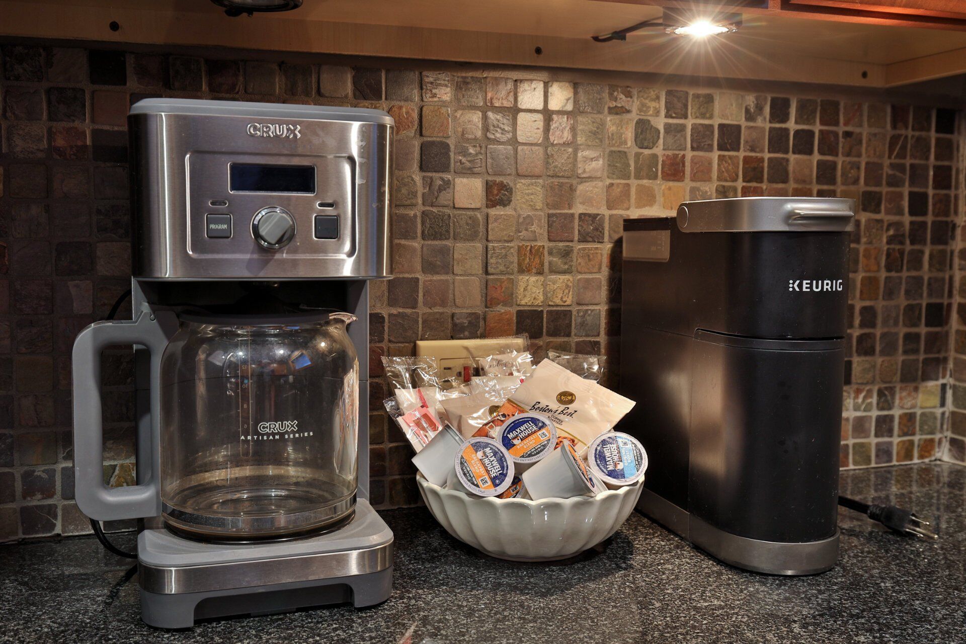 Una cafetera, una cafetera Keurig, i un suport per a càpsules de cafè damunt una cuina.