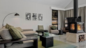 A modern living room with a sofa, coffee table, and a fireplace.
