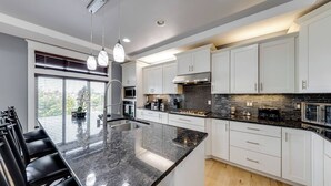 A modern kitchen with white cabinets, a large island, and a black countertop. - WATER FRONT PROPERTY WITH PRIVATE BOAT DOCK (Ferndale)