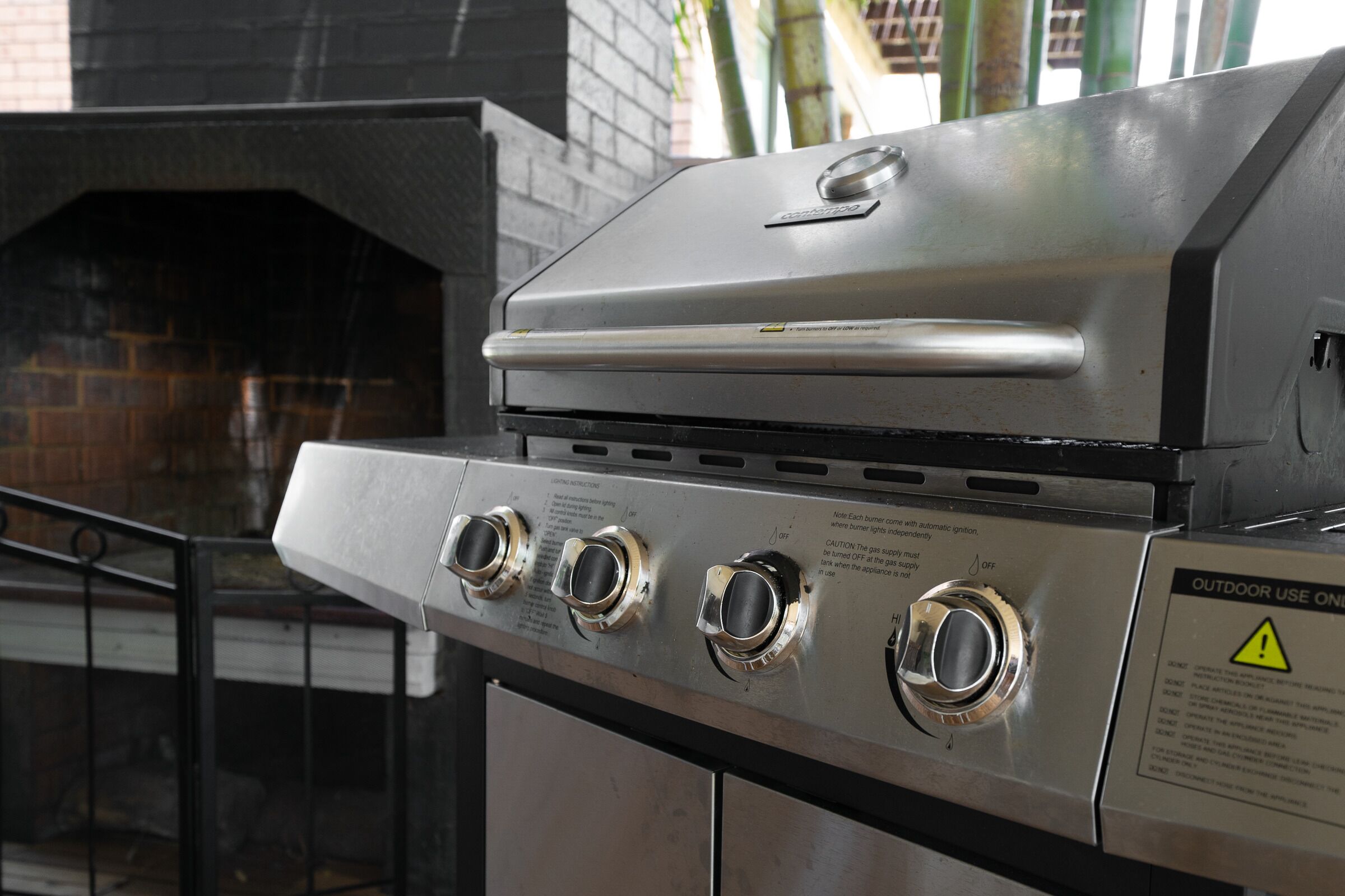 Un barbecue extérieur en acier inoxydable, doté de trois brûleurs et d’un panneau de commande.