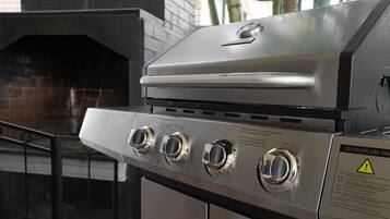 Un barbecue extérieur en acier inoxydable, doté de trois brûleurs et d’un panneau de commande.