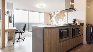 A modern kitchen with a large island, built-in appliances, and a view to the outside.
