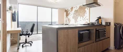A modern kitchen with a large island, built-in appliances, and a view to the outside.