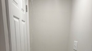 A narrow hallway with a white door on the left and a light switch on the wall. - Peaceful retreat in west Baltimore (Baltimore)