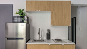 Une cuisine moderne dotée d’appareils électroménagers en acier inoxydable, de meubles de rangement en bois, d’un évier et d’un plan de travail.