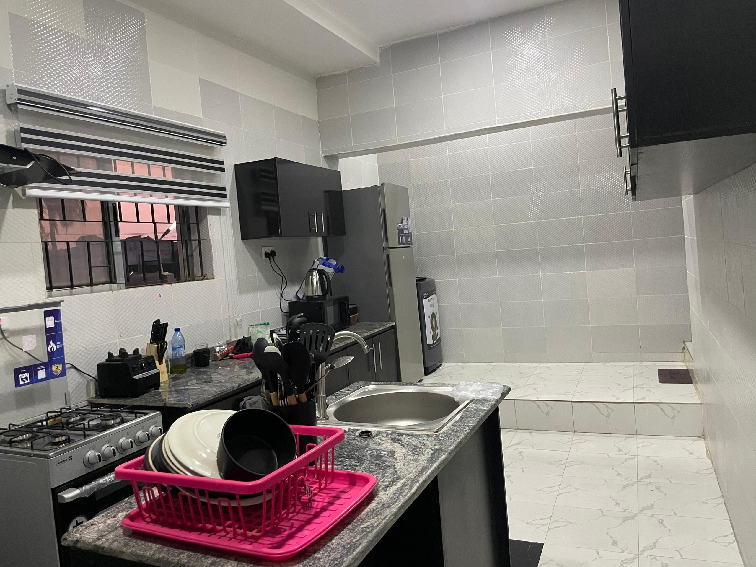 A compact kitchen with a gas stove, a sink, and a microwave.