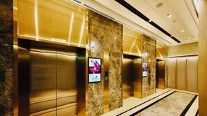 A modern elevator area with marble walls and metallic elevator doors. - Agile Luxury Suite at TRX KLCC (Kuala Lumpur)