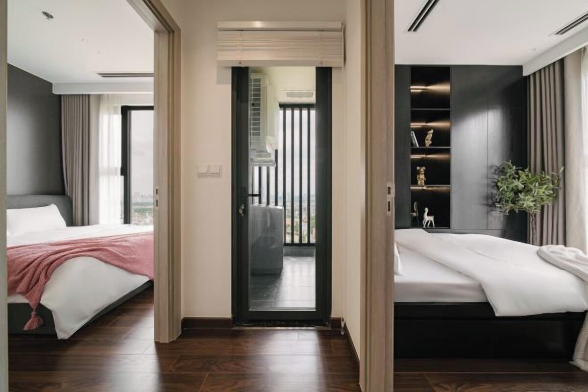 Ein modernes Hotelzimmer mit einem großen Bett, einer kleinen Sitzecke und einem Balkon mit Blick.