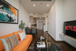 A modern living room with a sofa, a coffee table, and a TV displaying 'NETFLIX'.