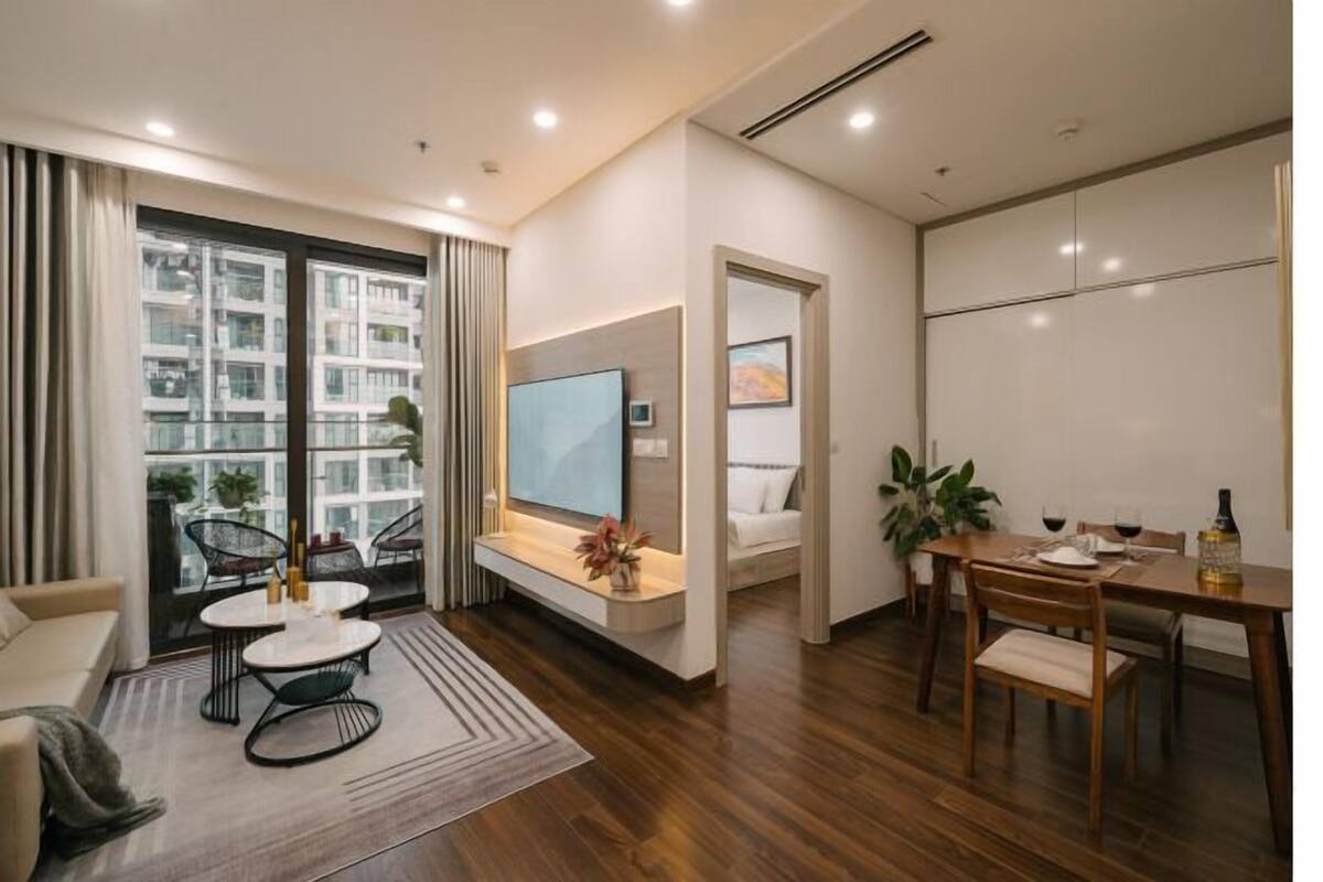 Uma sala de estar moderna com sofá, mesa de centro e área de jantar.