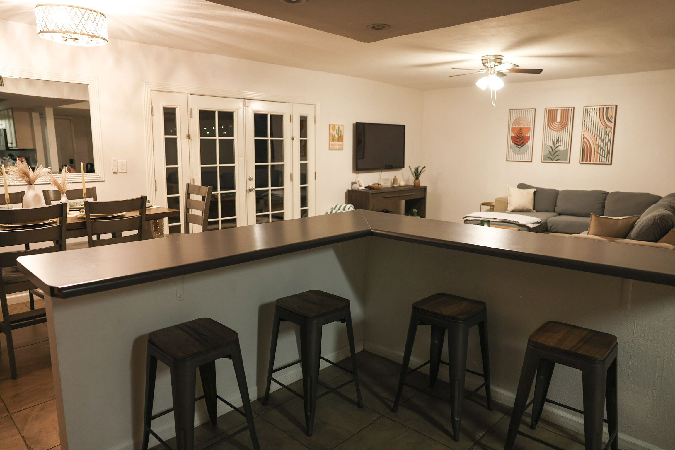 Una cocina moderna con barra, mesa de comedor y sofá.