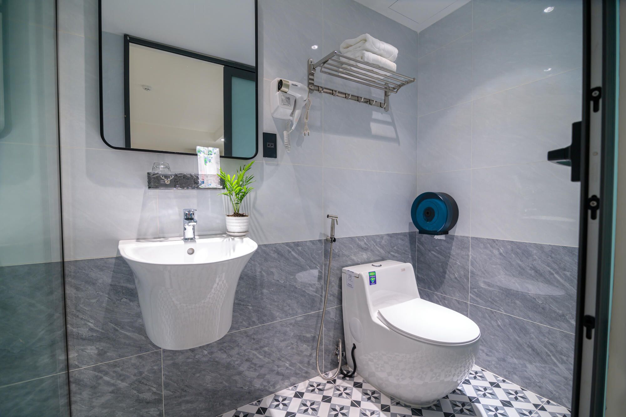 A modern bathroom with a white sink, a toilet, and a glass shower enclosure.