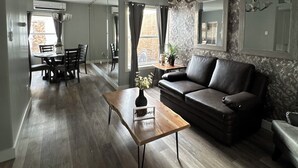 A modern living room with a leather sofa, a wooden coffee table, and a dining area with a table and chairs. - Modern House w/Wifi/alberca, Airport & Consulate in Hermosillo (Hermosillo)