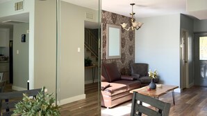 Uma sala de estar moderna com uma mesa de jantar de madeira escura, um vaso branco com folhagem verde e um lustre.